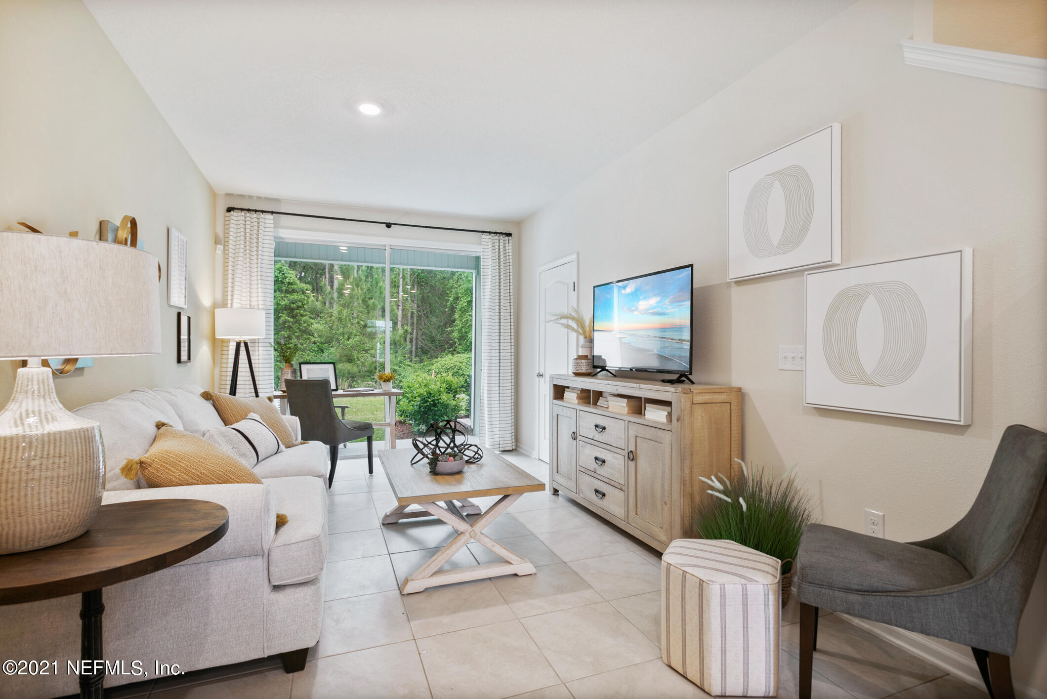 3972 Oak Mill Road Orange Park, FL 32065 - Photo 10 of 24 a living room with furniture a flat screen tv and a floor to ceiling window
