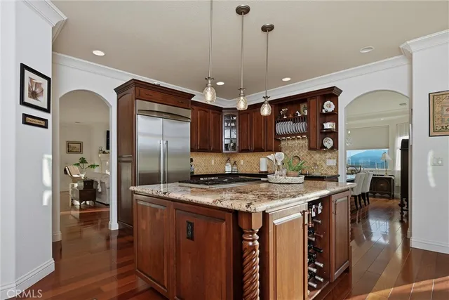 a kitchen with stainless steel appliances granite countertop a sink and a refrigerator