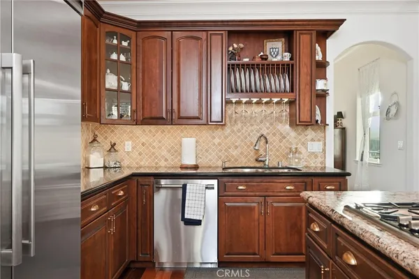 a kitchen with stainless steel appliances granite countertop a sink and a refrigerator