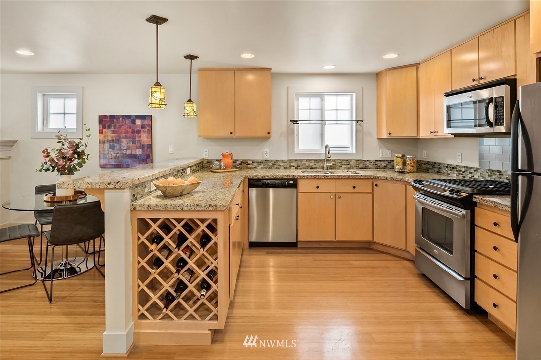 723 North 95th Street, Unit B Seattle, WA 98103 - Photo 3 of 24 a kitchen with stainless steel appliances granite countertop a stove a sink and a microwave