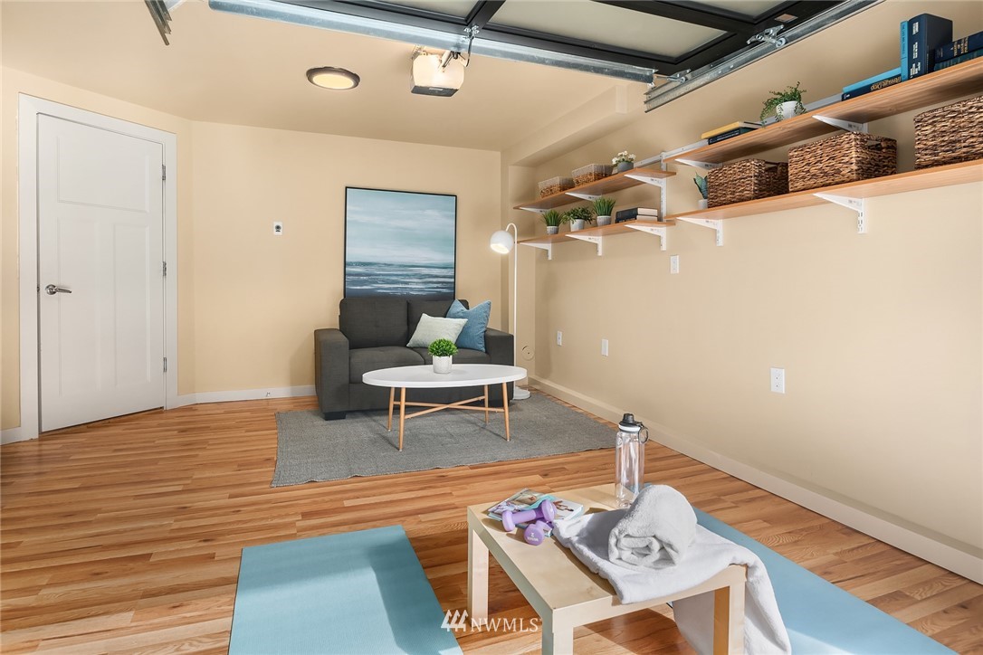 723 North 95th Street, Unit B Seattle, WA 98103 - Photo 21 of 24 a living room with couches and a dining table with wooden floor