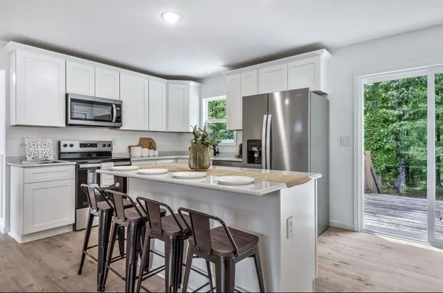 a kitchen with stainless steel appliances granite countertop white cabinets a sink and dishwasher