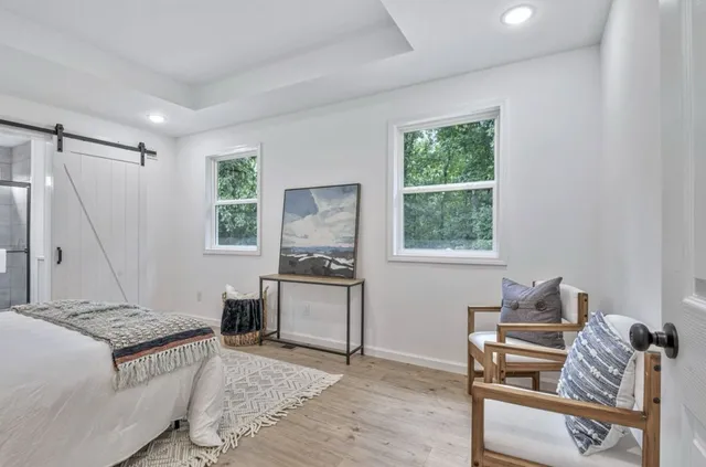 a bedroom with a bed and large windows