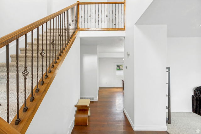 1585 South 910 West Payson, UT 84651 - Photo 3 of 32 Grand foyer featuring a wood and wrought iron staircase with carpeted treads, a second-story landing with matching railing, and wood-finish flooring extending into a hallway