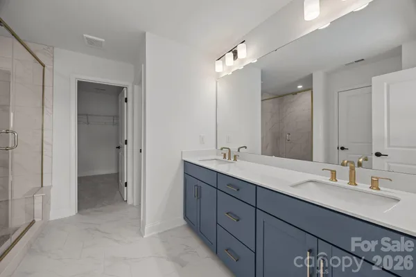 a bathroom with a double vanity sink shower and a mirror