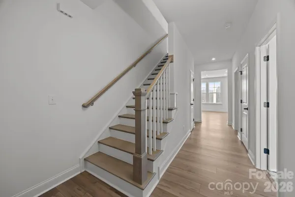 a view of a hallway with wooden floor and entryway
