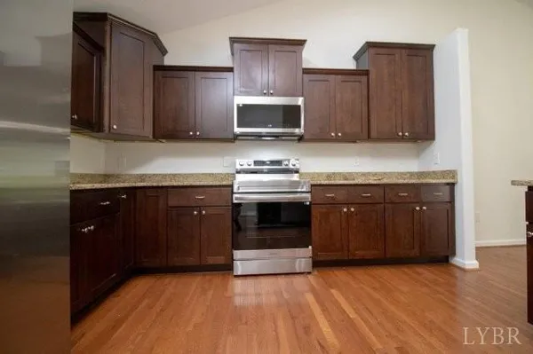 a kitchen with stainless steel appliances granite countertop wooden cabinets and a granite counter tops