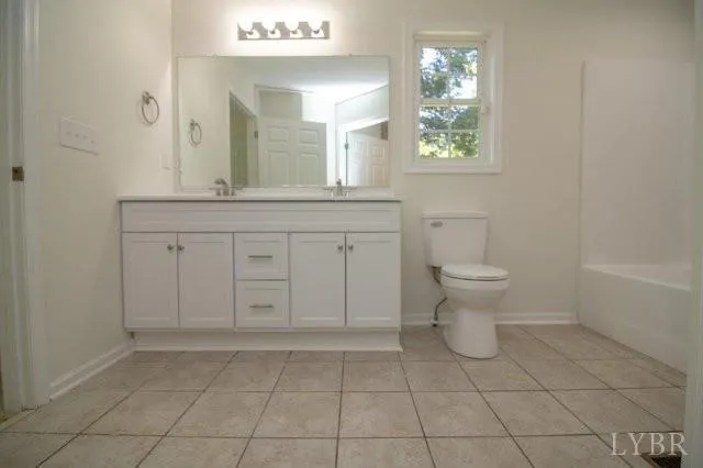 a spacious bathroom with a toilet a sink a mirror and a window