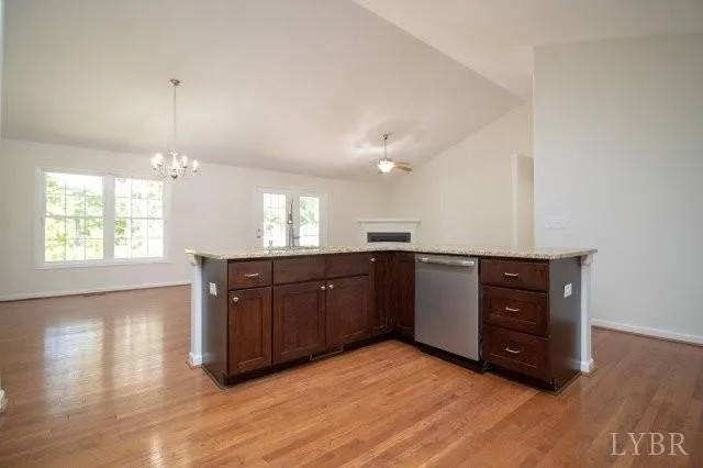 a kitchen with stainless steel appliances granite countertop a stove a sink a refrigerator and a wooden floors