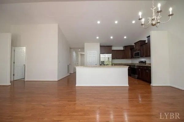 a view of kitchen with kitchen island stainless steel appliances refrigerator stove microwave and cabinets
