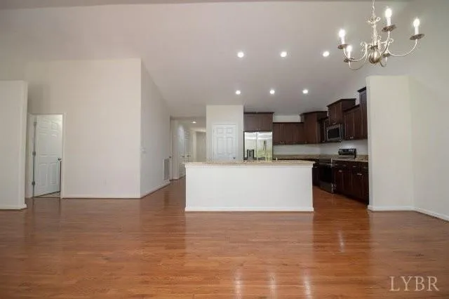 a view of kitchen with kitchen island stainless steel appliances refrigerator stove microwave and cabinets