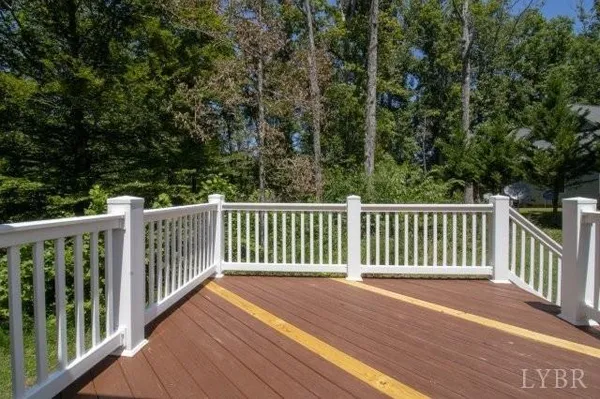 a view of backyard with deck and floor to ceiling window