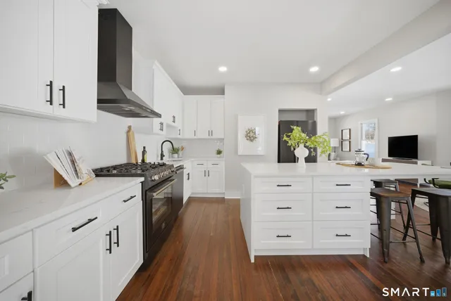 a kitchen with stainless steel appliances white cabinets and a wooden floor