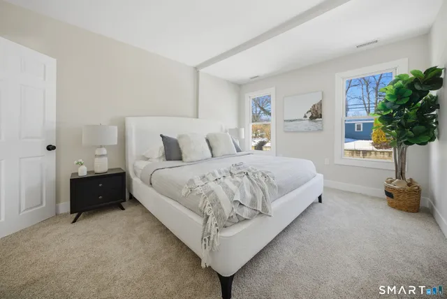 a bedroom with a bed and a potted plant
