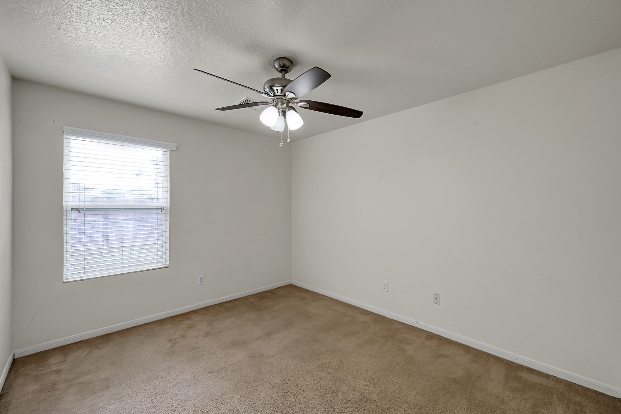 22518 Goss Spring Court Spring, TX 77373 - Photo 12 of 19 This room is bright and spacious with neutral-colored walls and carpet. It features a ceiling fan with lights and a window that allows natural light to fill the space.
