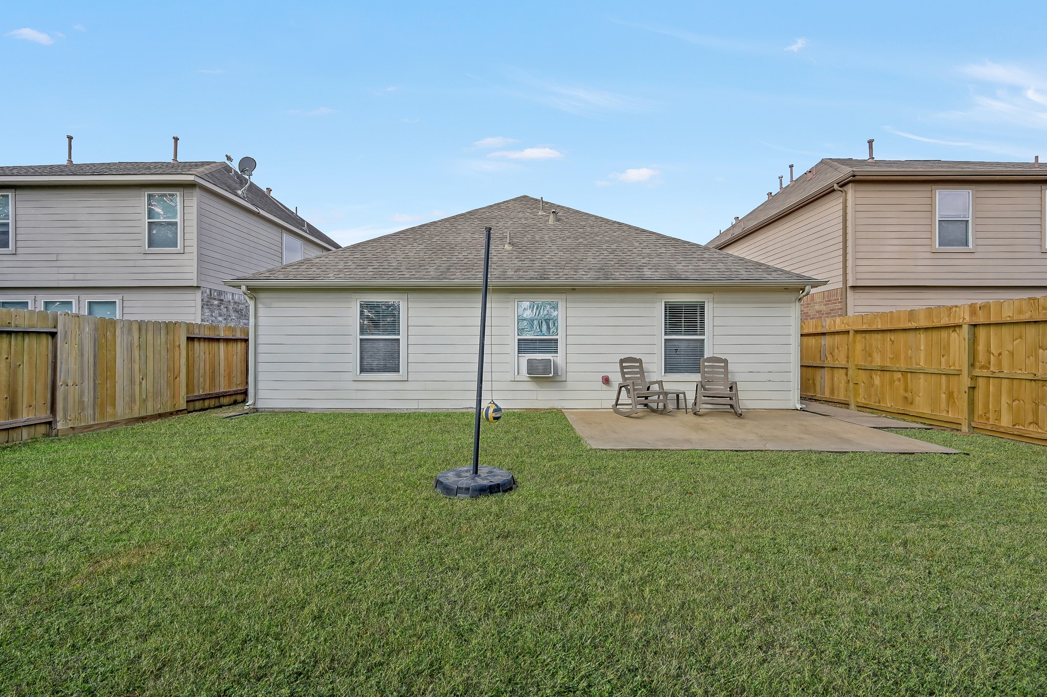 22518 Goss Spring Court Spring, TX 77373 - Photo 19 of 19 Cozy backyard with a small patio area, featuring two chairs for relaxation. The yard is enclosed by a wooden fence for privacy, with well-maintained grass for outdoor enjoyment.