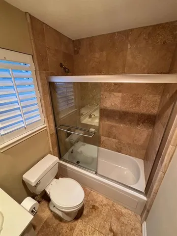 a bathroom with a toilet and a shower