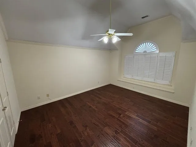 en view of empty room with wooden floor and fan