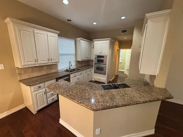 a kitchen with stainless steel appliances granite countertop a sink stove and cabinets