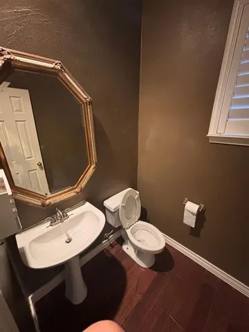 a bathroom with a sink mirror and toilet