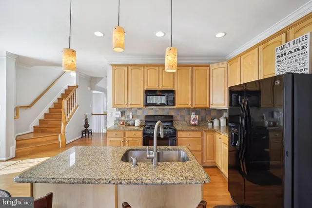 a kitchen with stainless steel appliances granite countertop a refrigerator a stove and a sink