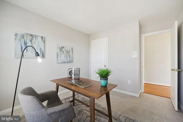 a workspace room with furniture and potted plant