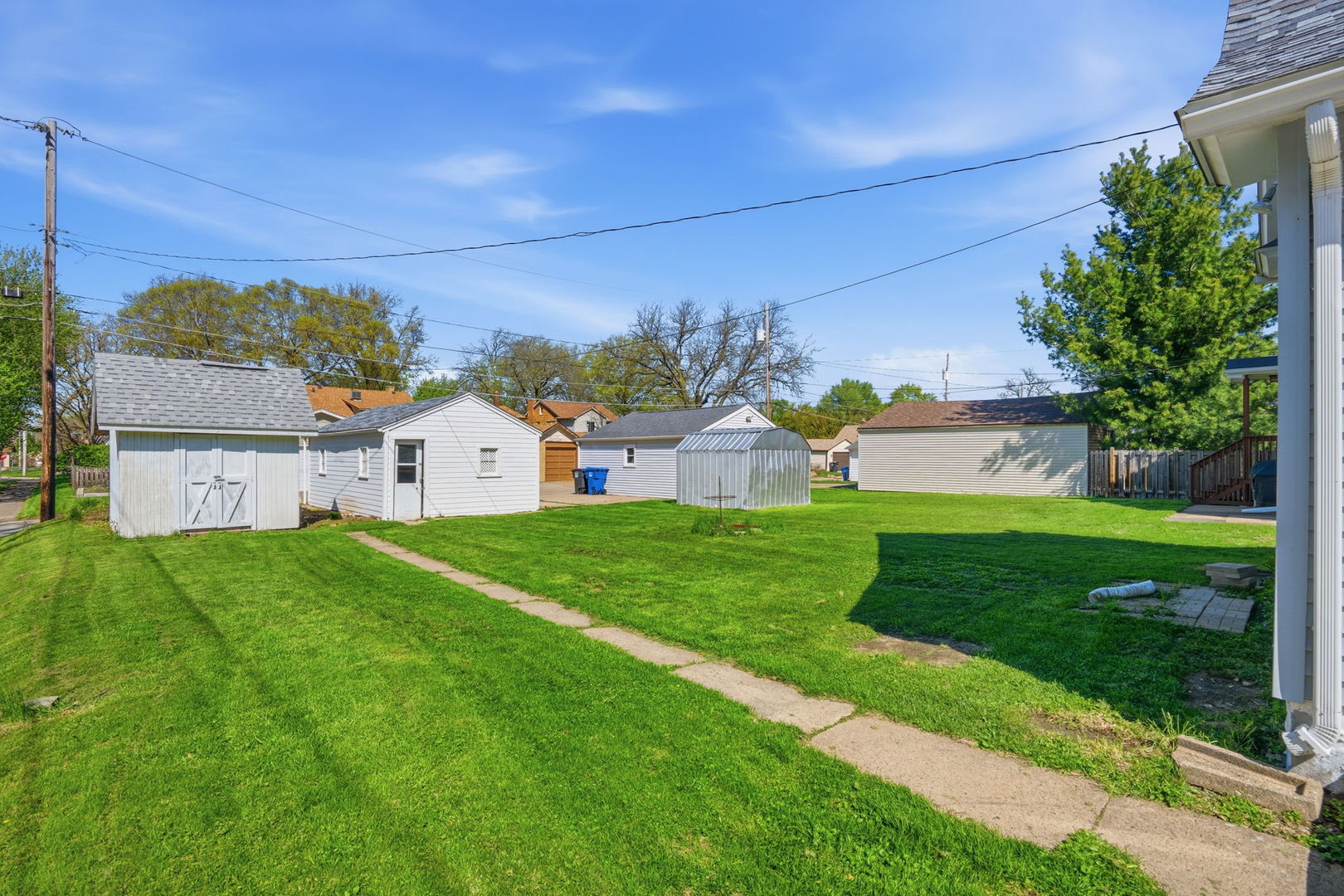 1927 14th Street Moline, IL 61265 - Photo 22 of 25 a view of a house with a big yard potted plants and large tree