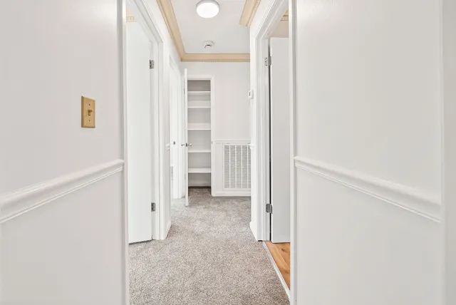 a view of a hallway with wooden floor and entryway