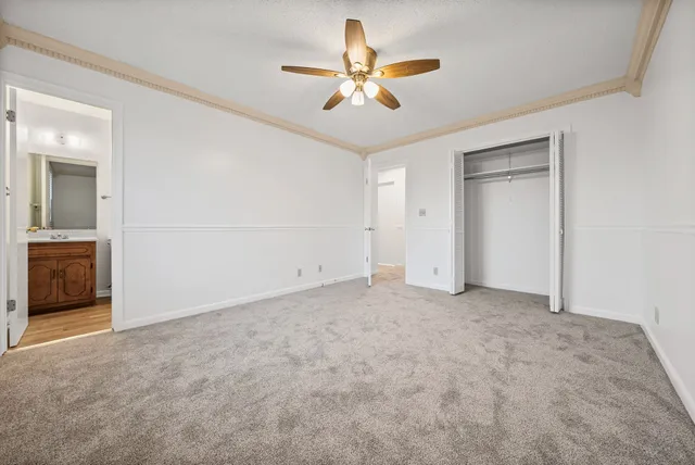 an empty room with a ceiling fan and a window