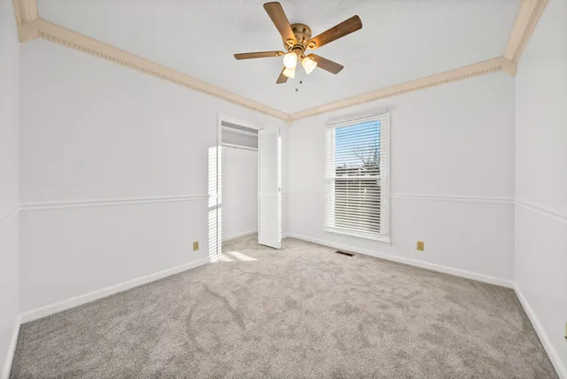 an empty room with a window and a ceiling fan