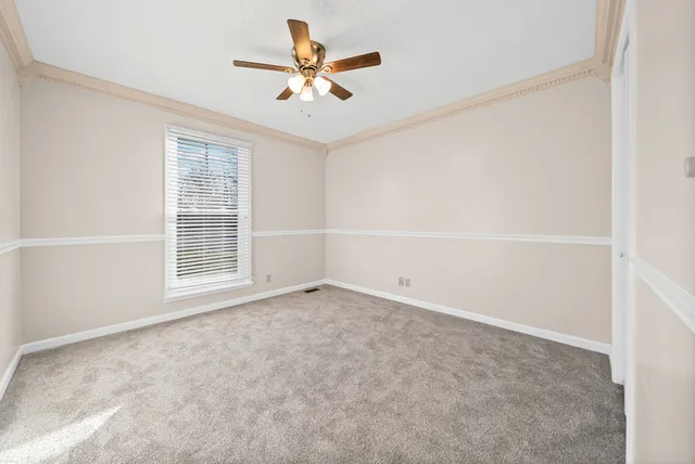 an empty room with window and ceiling fan