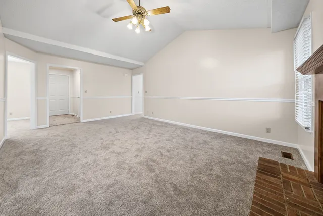 an empty room with a ceiling fan and a window