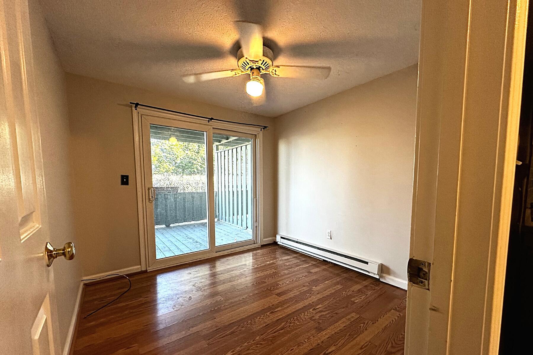70 North Street, Unit E Hyannis, MA 02601 - Photo 11 of 29 an empty room with wooden floor fan and windows