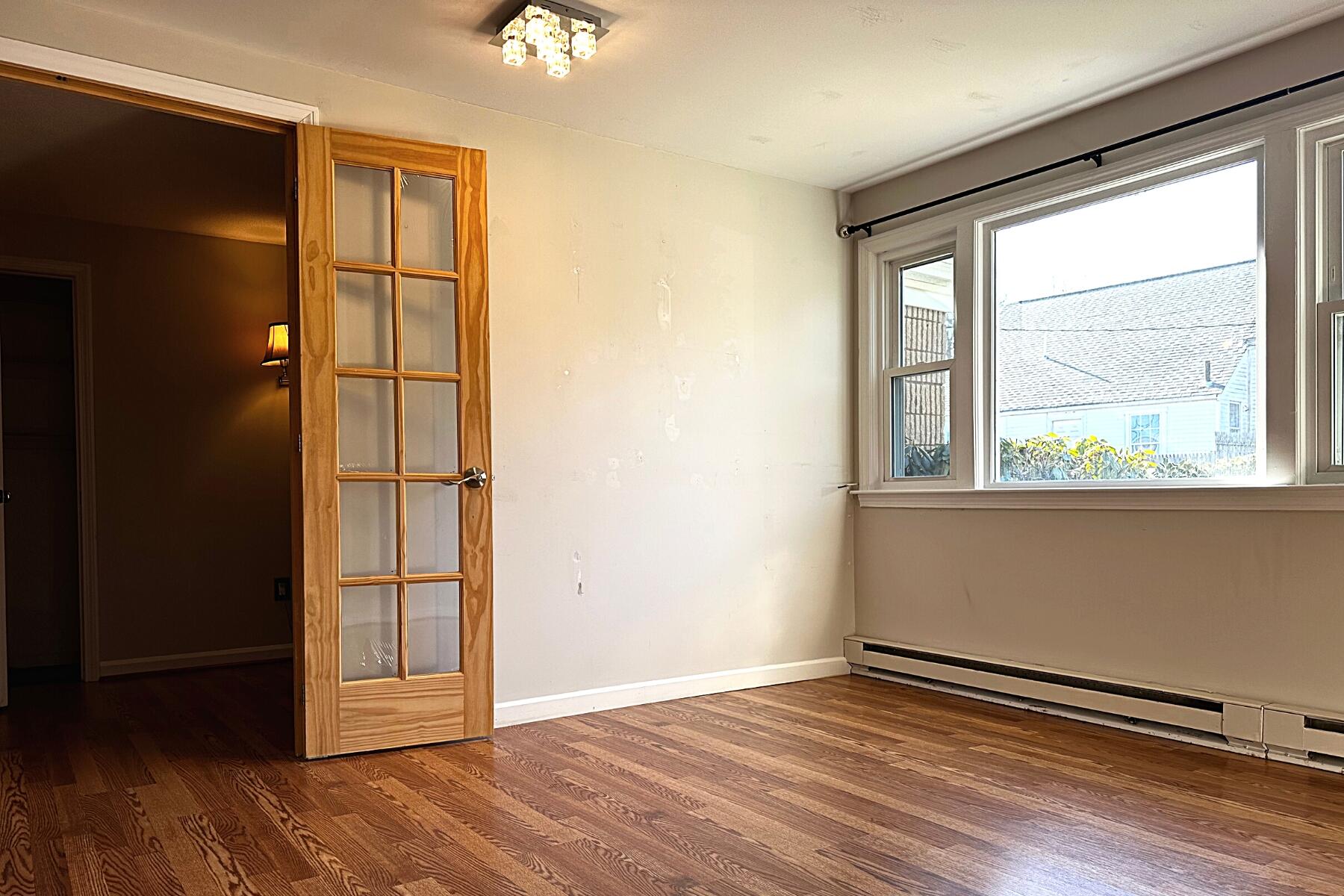 70 North Street, Unit E Hyannis, MA 02601 - Photo 14 of 29 an empty room with wooden floor cabinet and windows