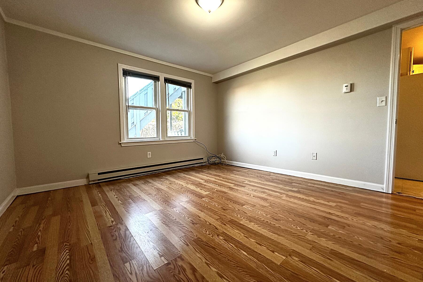 70 North Street, Unit E Hyannis, MA 02601 - Photo 15 of 29 an empty room with wooden floor and windows