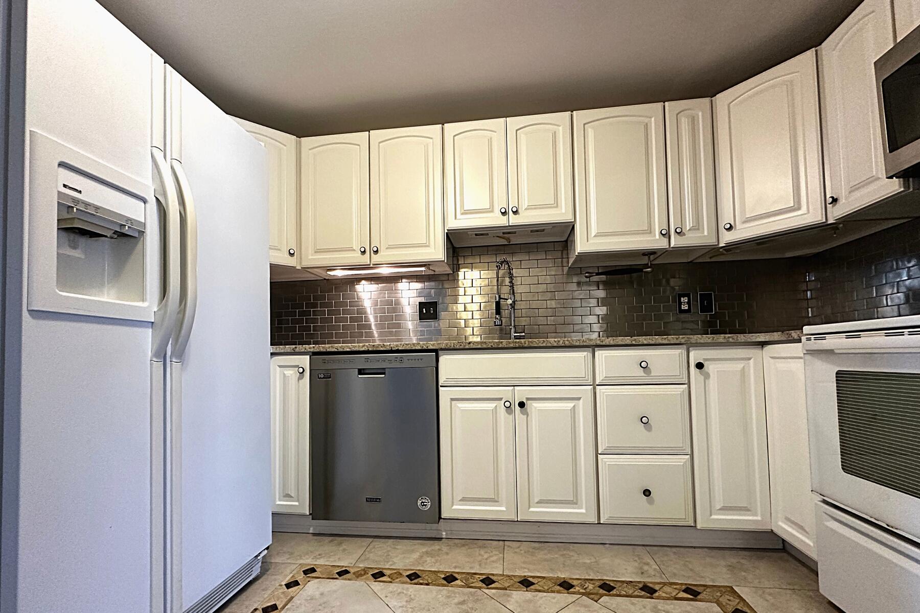 70 North Street, Unit E Hyannis, MA 02601 - Photo 4 of 29 a kitchen with stainless steel appliances granite countertop a refrigerator sink and cabinets