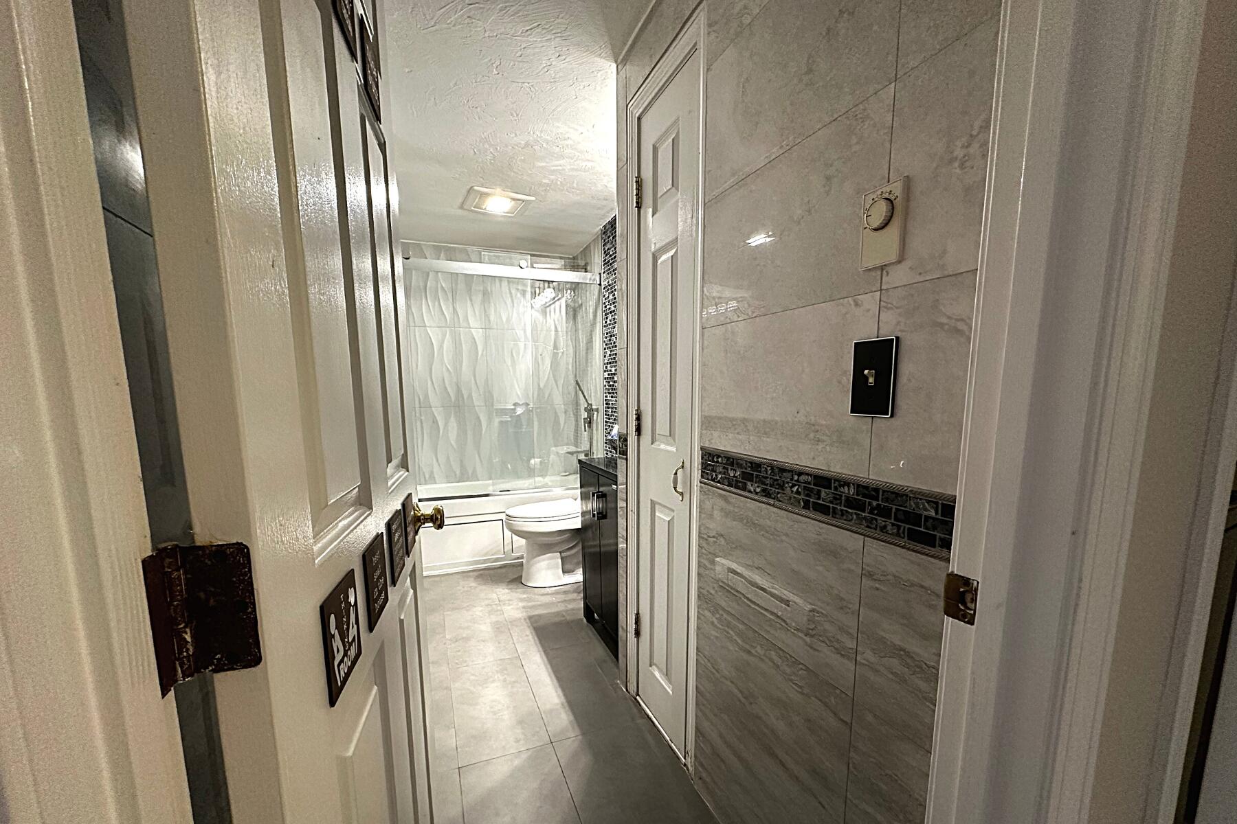 70 North Street, Unit E Hyannis, MA 02601 - Photo 6 of 29 a bathroom with a granite countertop sink a toilet a mirror and shower