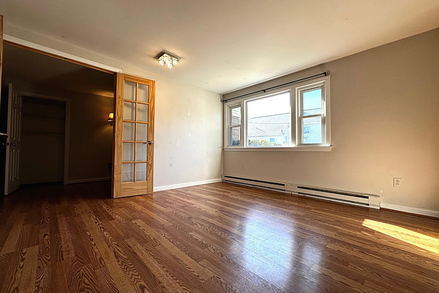 70 North Street, Unit E Hyannis, MA 02601 - Photo 10 of 29 an empty room with wooden floor and windows