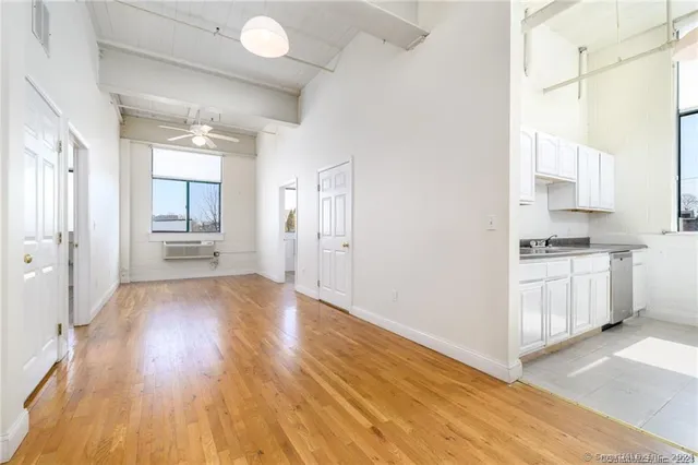 a view of empty room with wooden floor and window