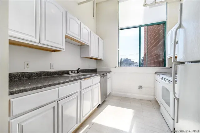 a kitchen with stainless steel appliances granite countertop a sink and a stove