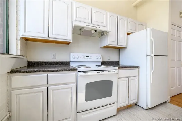 a kitchen with stainless steel appliances white cabinets and a refrigerator