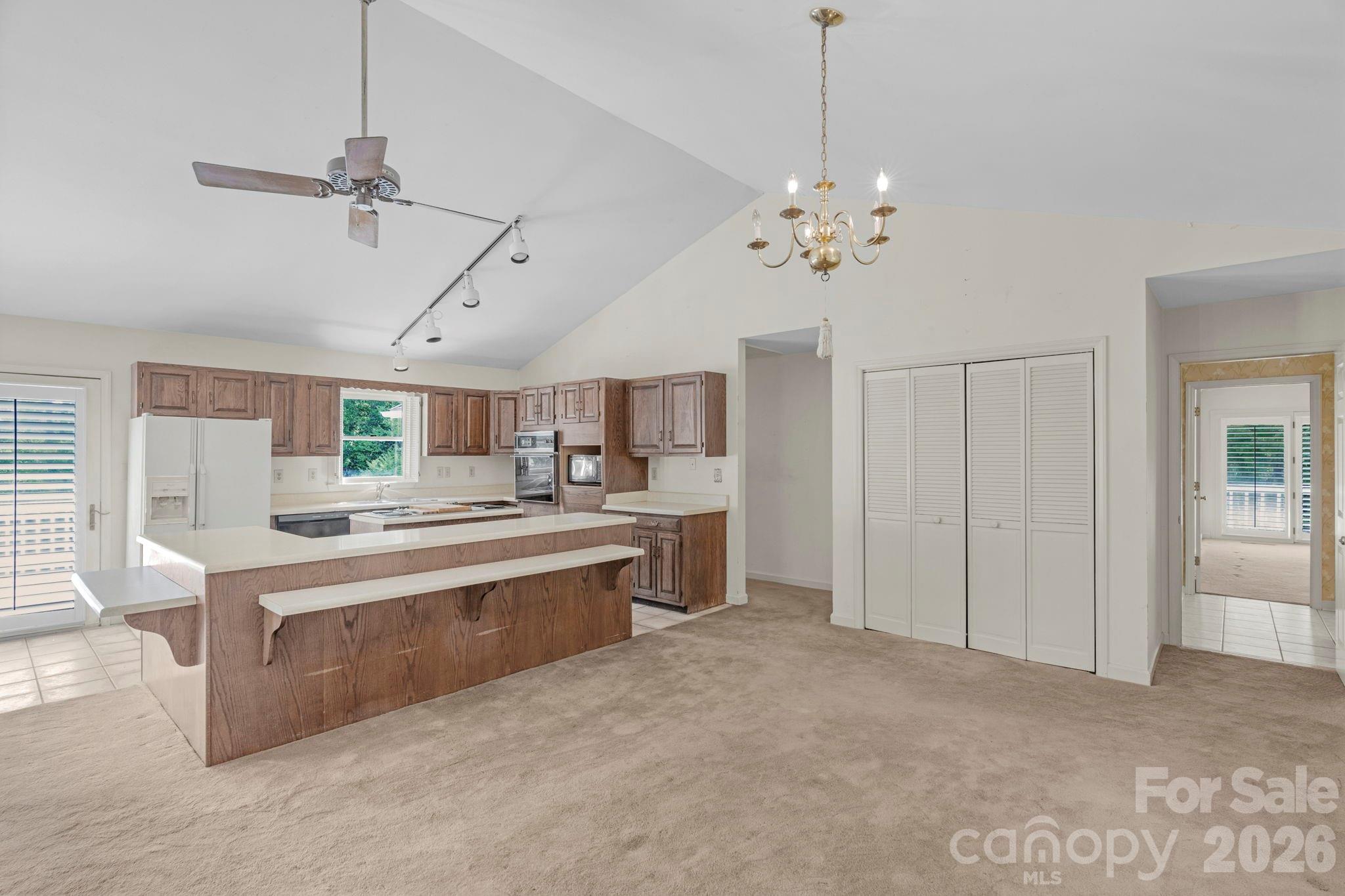 15015 Pawnee Trail Matthews, NC 28104 - Photo 14 of 39 a kitchen with kitchen island a stove a sink and a chandelier