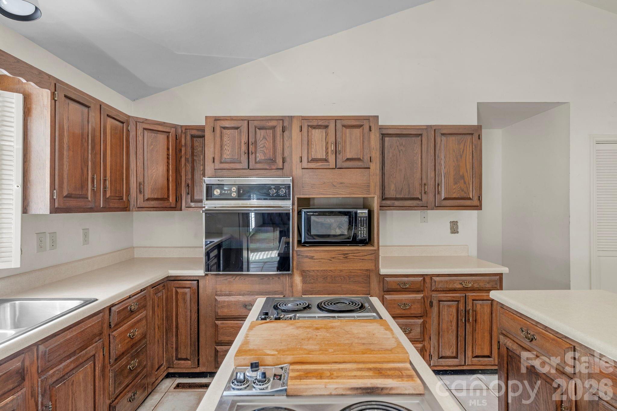 15015 Pawnee Trail Matthews, NC 28104 - Photo 8 of 39 a kitchen with kitchen island granite countertop a stove top oven a sink dishwasher and cabinets with wooden floor
