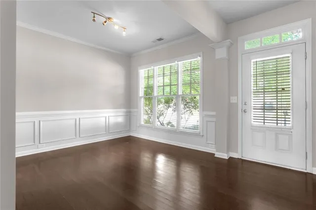 an empty room with wooden floor and windows