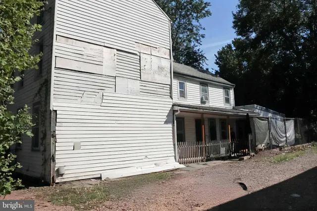 a view of a house with a yard and large tree