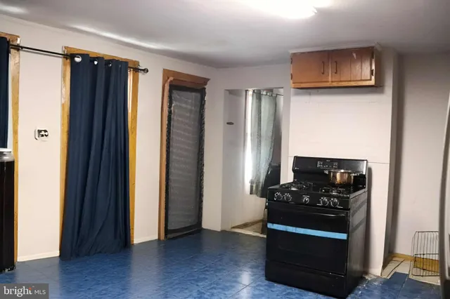 a view of kitchen with stainless steel appliances granite countertop a refrigerator and a stove top oven