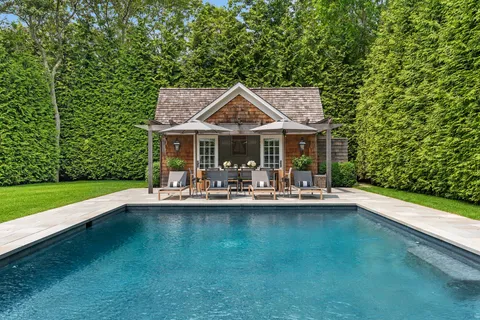 a front view of a house with swimming pool having outdoor seating