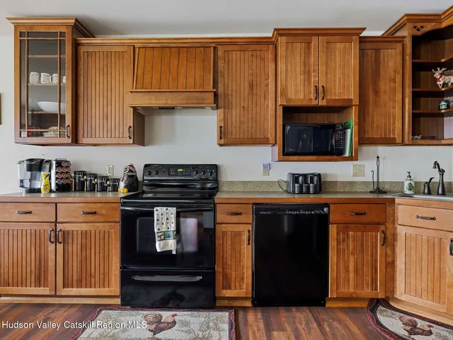 a kitchen with stainless steel appliances granite countertop a stove a sink dishwasher and a microwave oven with cabinets