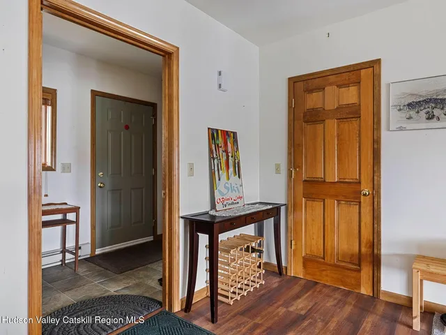 a view of a hallway with wooden floor and furniture