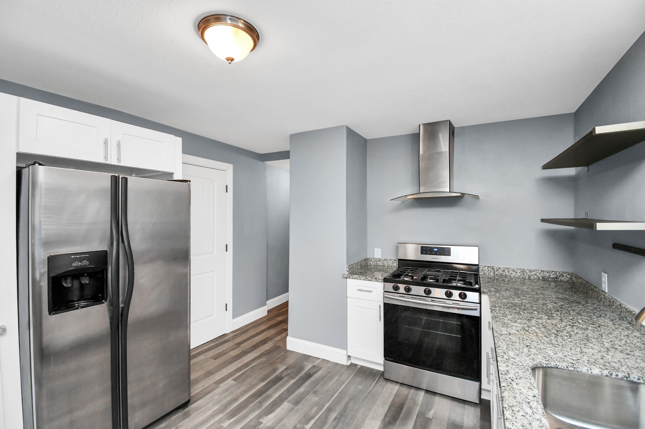 3217 Michigan Street Baytown, TX 77520 - Photo 14 of 37 a kitchen with stainless steel appliances granite countertop a refrigerator a sink and wooden floors